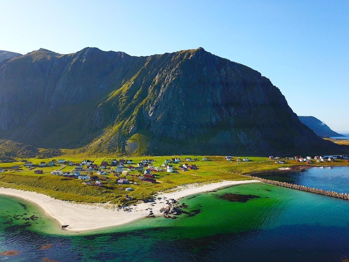 Beach and green valley below steep mountains